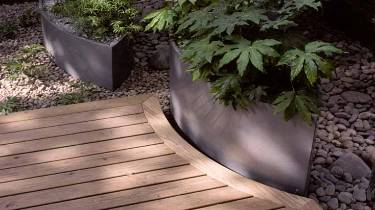Hardwood deck with edge bent to shape of eliptical planter