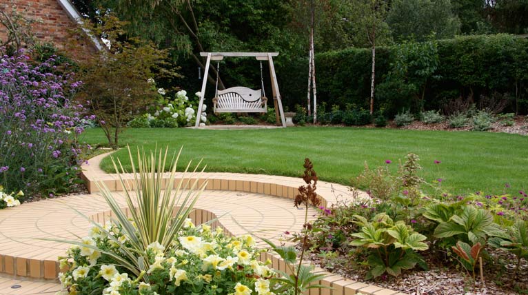Oak swing seat a focal point across the terraced lawn